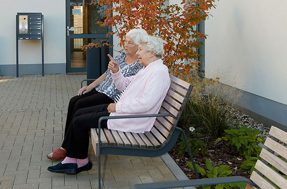 Rentner sitzen auf Bank vor Seniorenresidenz Pohlandplatz